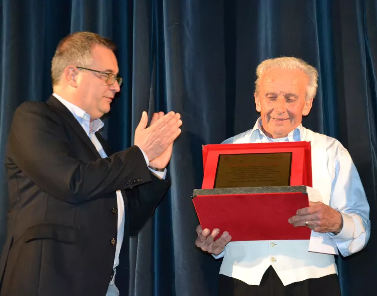 Il sindaco Marco Gallo consegna a Giangi Giordano una targa che testimonia la riconoscenza di Busca alla lunga attività della filodrammatica