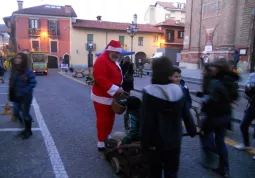 Babbo Natale offre dolcini ai bimbi, mentre passa il 'suo' trenino