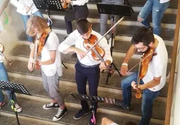 Alcuni allievi del Vivaldi accolgono i visitatori sulla scalinata del Palazzo della Musica, sabato scorso per l'open day