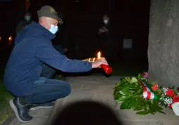 Un Alpino accende la luce della Libertà, un cero posto ai piedi del monumento alla Resistenza, dal quale i ragazzi accendono ciascuno una candela  in segno del passaggio generazionale dei valori del 25 Aprile