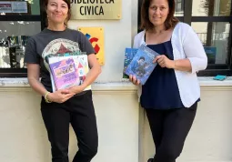 La bibliotecaria Noemi Balbo e l'assessora Lucia Rosso mostrano i nuovi libri arrivati dall'Ucraina