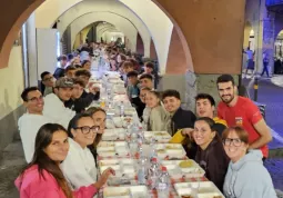 Le tavolate disposte sotto i portici della via centrale