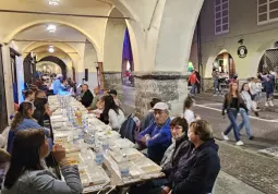 Le tavolate disposte sotto i portici della via centrale